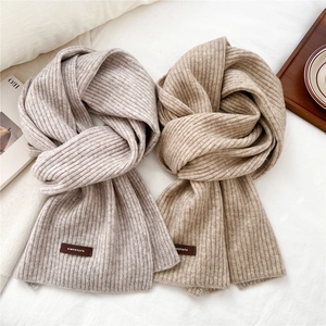 Detailed knit texture and leather brand label on thick ribbed winter scarves