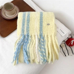 Close-up of yellow and blue striped wool scarf texture with tassels and metal tag