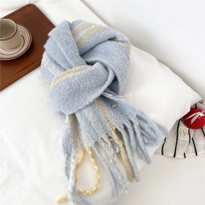 Detailed view of striped wool-blend scarf with long tassels and soft knit texture