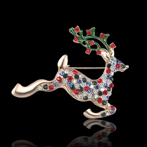 Exquisite golden reindeer brooch with colorful rhinestones and green enamel on black surface