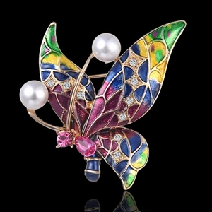 Detail of colorful enamel butterfly brooch with gold plating, pearls and rhinestones