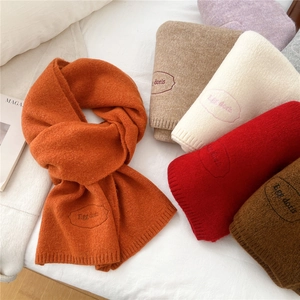 Thick knitted scarves in various colors with embroidered labels for winter warmth