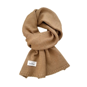 Khakifarbener Grobstrickschal mit bunten Punkten und Design-Label in geknoteter Form