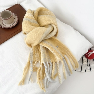 Close-up of yellow and grey striped wool scarf with thick knit texture and tassels