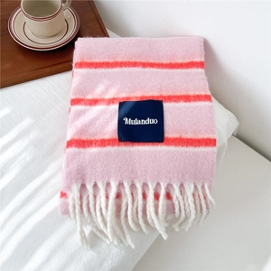 Detailed macro view of pink striped wool blend scarf with thick fringe and blue brand label