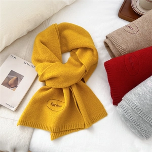 Detail of knitted winter scarf showing various colors and Egg doris embroidery logo