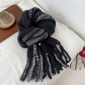 Detail of thick wool blend knit scarf with tassels and grey striped texture