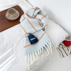 Detail of thick wool striped scarf with soft fringe tassels and navy brand tag