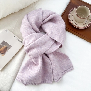 Close-up of light purple knitted scarf texture featuring a heart-shaped embroidered patch