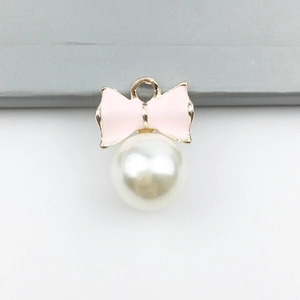Golden pendant featuring a pink enamel bow and white pearl for DIY jewelry making