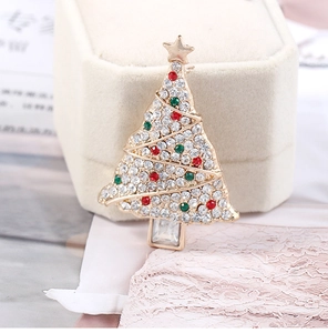 Macro shot of Christmas tree brooch with colorful rhinestones on a golden alloy base
