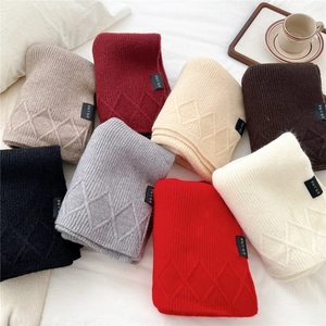 Detailed macro view of diamond-pattern knit scarves in various colors and soft texture
