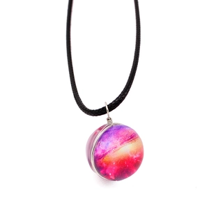Macro detail of handmade cosmic galaxy glass orb pendant with colorful nebula and cord