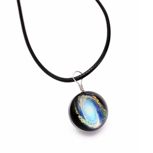 Close-up of a handmade galaxy glass ball pendant featuring a nebula on a black cord