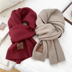 Close-up of thick ribbed knit texture and woven label on striped winter scarf