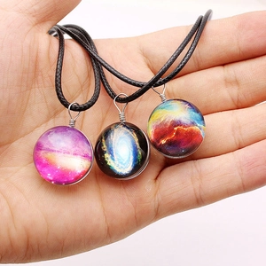Cosmos galaxy double-sided glass ball pendant necklace with black cord on white background