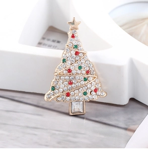 Macro detail of Christmas tree brooch with white rhinestones and green crystal accents