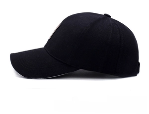 Side view of classic black cotton baseball cap with curved brim and brown side patch