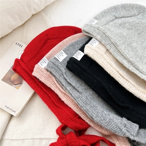 Close-up of colorful ribbed knit beanies stacked with warm texture and woven labels