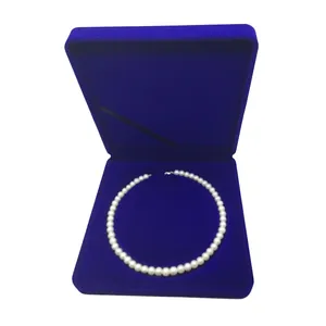 Detailed view of round white pearl necklace in a premium navy blue velvet jewelry gift box