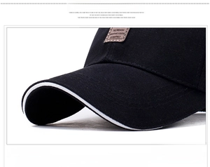 Detail of black baseball cap with white contrast brim edging and premium logo label