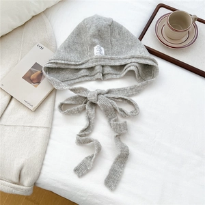Gray knitted balaclava with lace-up detail and soft wool texture for winter warmth