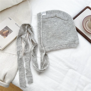 Detailed knit texture of grey hooded scarf hat on aesthetic home setting background