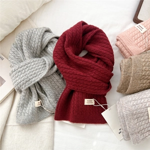 Sciarpe invernali in maglia spessa da donna in vari colori su un letto accogliente