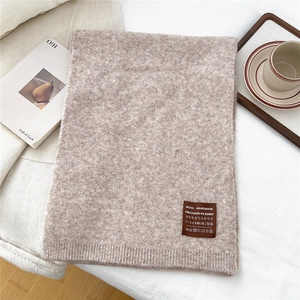 Detail of oatmeal knit scarf with handmade wool label and premium textured weave