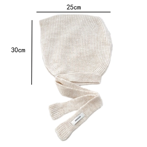 Close-up of beige knitted hooded scarf showing fine texture and woven brand label