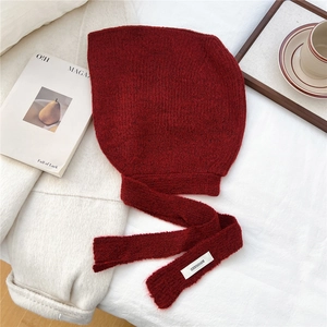 Close-up of deep red knitted hoodie scarf featuring a white woven brand label