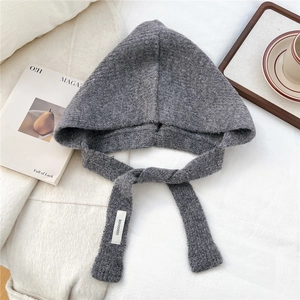 Close-up of gray knit hooded scarf showing thick texture and woven logo label