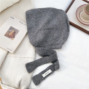 Detailed knit texture of dark grey hooded scarf with logo label and long ties