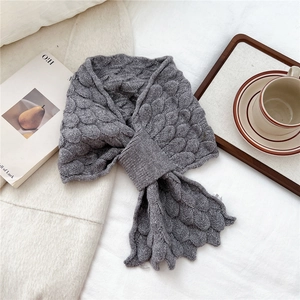Close-up of gray fish-scale knit scarf with pull-through loop on soft white fabric