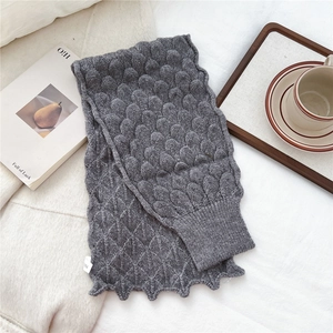 Detail of grey fish scale knit texture on a cozy winter scarf with ribbed cuff