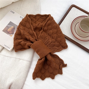 Detailed view of brown knit scarf with unique fish scale texture and loop closure