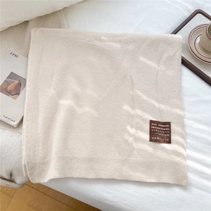 Gros plan sur l'écharpe en laine crème montrant la texture faite main et le tissage précis