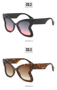 Detail view of butterfly wing sunglasses in black and tortoiseshell with gradient lenses