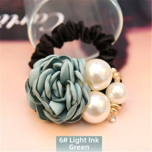 Detailed close-up of dark green satin rose flower and pearls on elastic hair tie