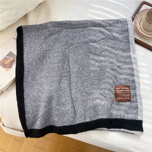 Close-up of handmade gray wool scarf with black border showing premium knit texture
