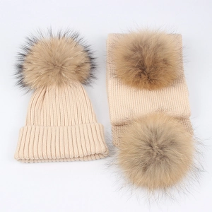 Winter knitted hat and scarf set with large fluffy fur pom-poms in beige rib-knit style