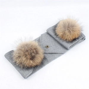 Grey knit winter neck warmer with fluffy brown pom poms and metal snap closure
