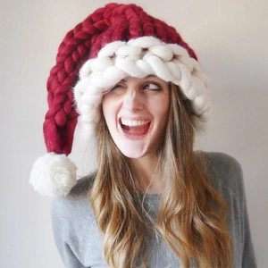 Close-up of handmade chunky knit Christmas hat with thick red and white wool texture