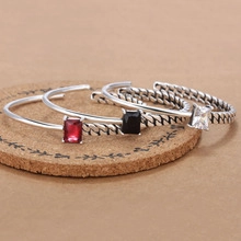 Detail of vintage open bangles featuring rectangular gemstones and twisted metal texture