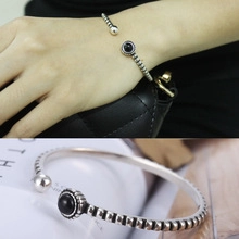Macro detail of retro dragon style open cuff bracelet with black agate and bead texture