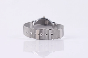 Detail of silver mesh strap and polished case back on a minimalist quartz watch