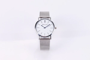 Close-up of minimalist silver mesh strap watch with clean white dial and black markers