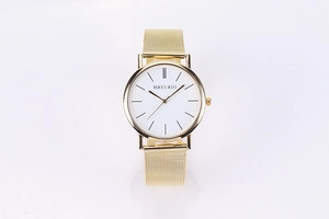Detail of minimalist gold mesh strap watch with white dial and metal indices