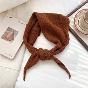 Close-up of caramel knit triangle scarf featuring intricate crochet texture and center knot