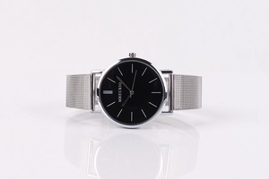 Close-up of Geneva mesh strap watch with black dial and silver stainless steel band
